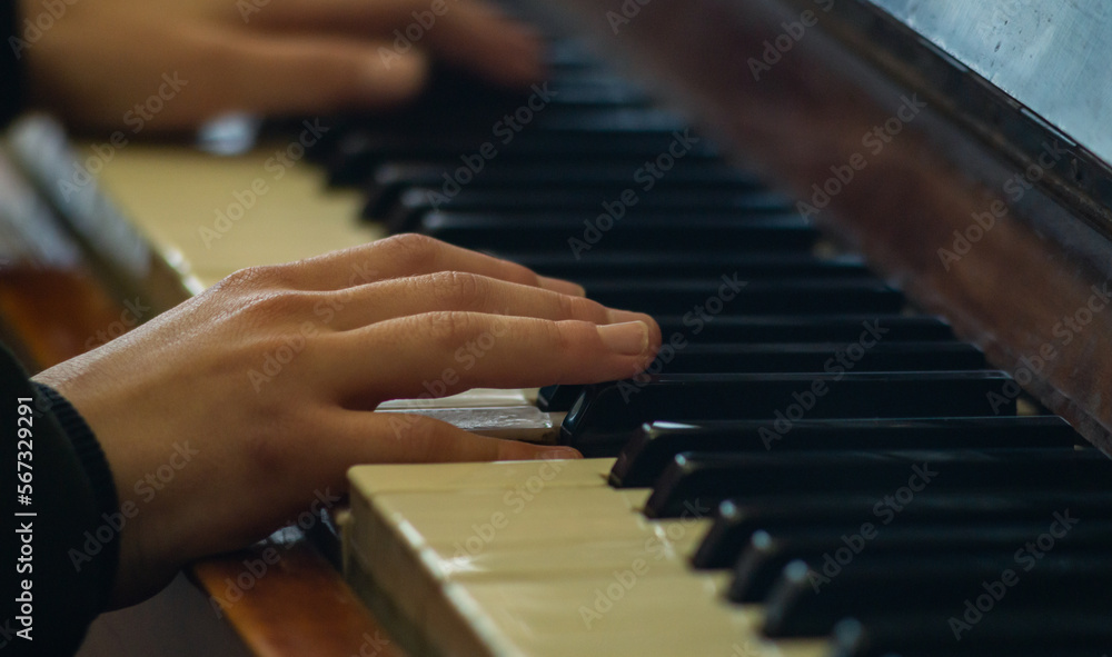 Two hands on the piano keys. A child plays the piano. The musician plays the piano. Close to the musician's hands Two hands on the piano keys. A child plays the piano. The musician plays the piano. Close to the musician's hands