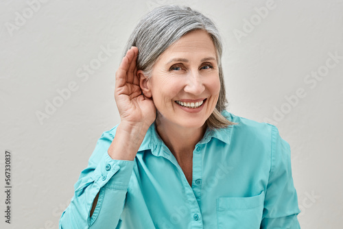 Mature woman listening sound with hand near ear for hearing check-up. Hearing test concept