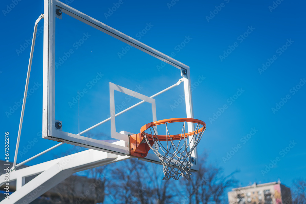 Basketball basket against the blue sky, sports ground in the city concept