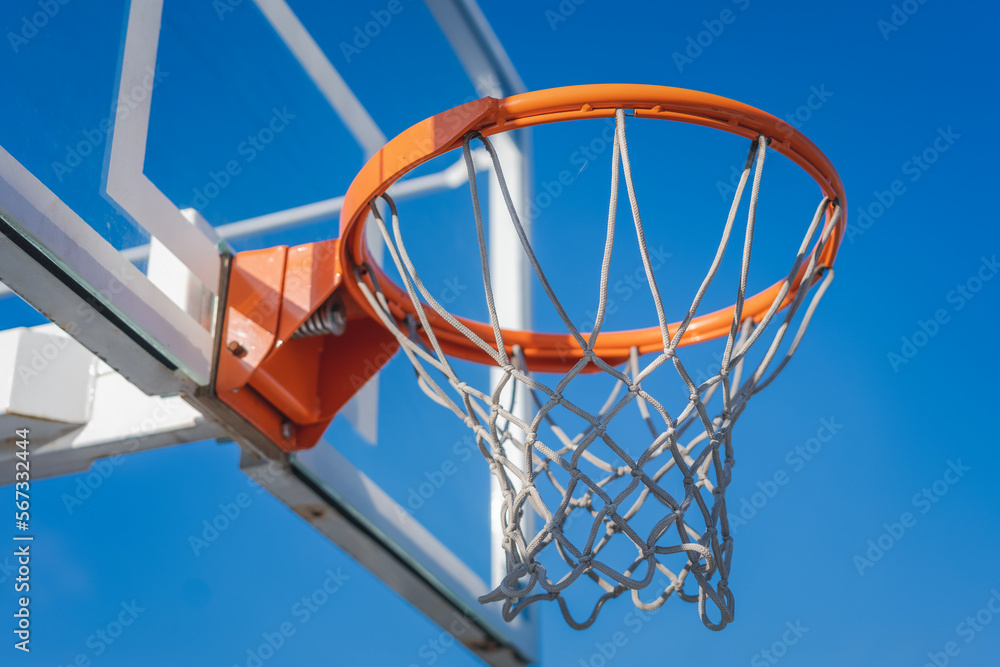 Basketball basket against the blue sky, sports ground in the city concept