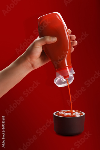 Canvas Print Tomato ketchup concept, a male hand squeezing ketchup bottle and the ketchup pou