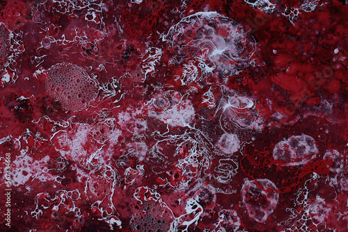 Spilled red and white paint on liquid thinner to form an abstract pattern.