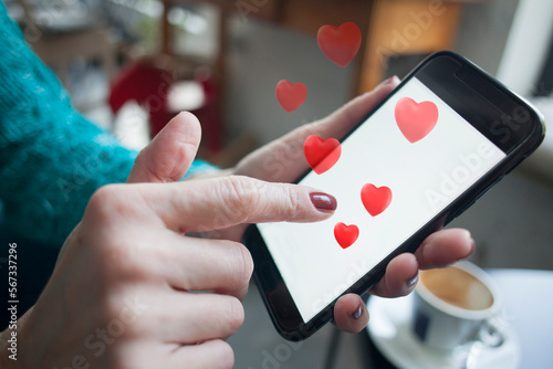 woman using smartphone with red hearts coming out