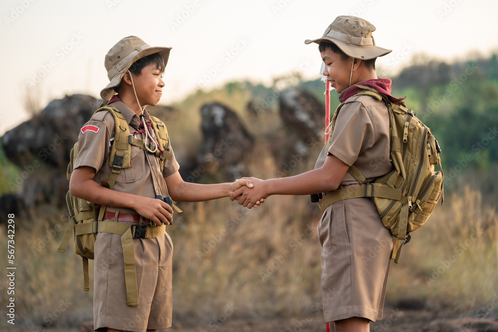 boy scouts handshake with left hand in greeting Boy Scout or  Congratulations Scouts holding hands have good teamwork in the camp. Scout  greeting concept. Stock Photo
