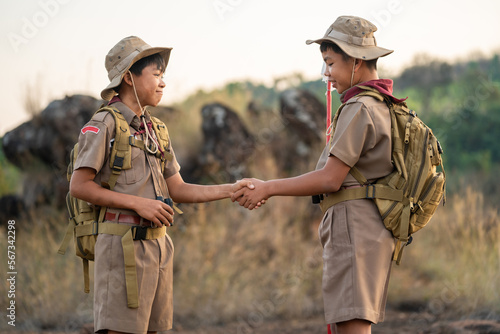 boy scouts handshake with left hand in greeting Boy Scout or Congratulations Scouts holding hands have good teamwork in the camp. Scout greeting concept. photo