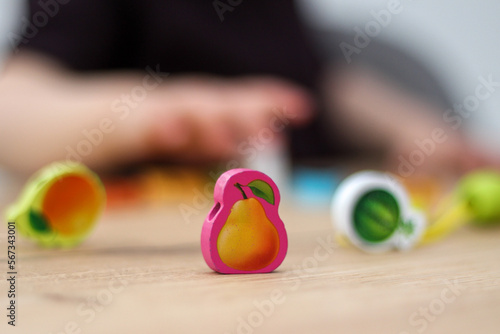 Child plays with beads and string. Fine motor skills development. Early education, Montessori Method