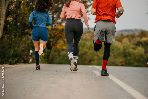 Fototapeta Naklejka Na Ścianę i Meble -  Rear view of a fitness sports people running lifestyle concept. Group of dedicated young people jogging together outdoors