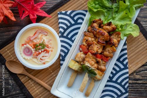Yakitori and Chawan Mushi - Japanese chicken skewer and steamed egg flat lay on wood table at top view photo