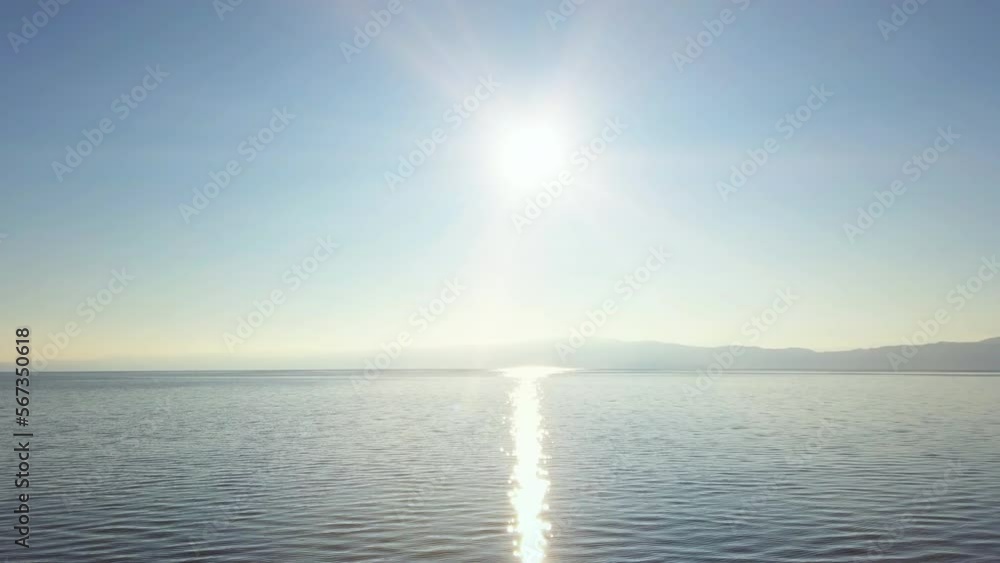 Panoramic view of a lake horizon with sun beams reflecting on the surface Panoramic view of a lake horizon with sun beams reflecting on the surface