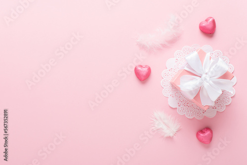 A mock-up of a Valentine's Day banner with a gift box, heart-shaped candies on a pink background.