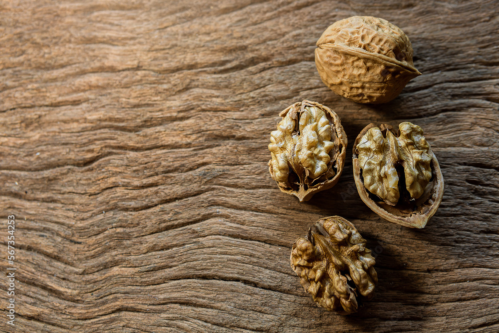 Raw brown organic walnut kernels with shell on rustic wooden table. Raw brown organic walnut kernels with shell on rustic wooden table.