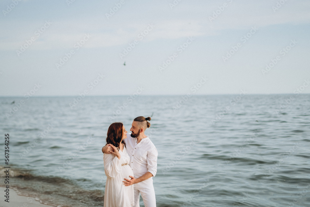 a guy with a girl in white clothes on the seashore