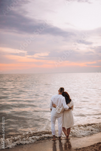 a guy with a girl in white clothes on the seashore