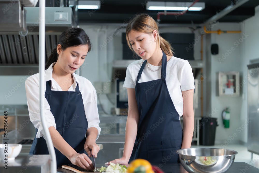 Cooking apprentices prepare meals and ingredients before the chef arrives to instruct at the culinary academy's kitchen. Cooking apprentices prepare meals and ingredients before the chef arrives to instruct at the culinary academy's kitchen.