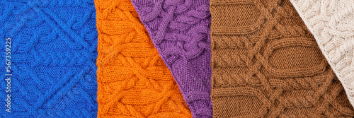 Knitted blue, lilac, brown, orange and beige background. Large knitted fabric with a pattern. Close-up of a knitted blanket. Banner