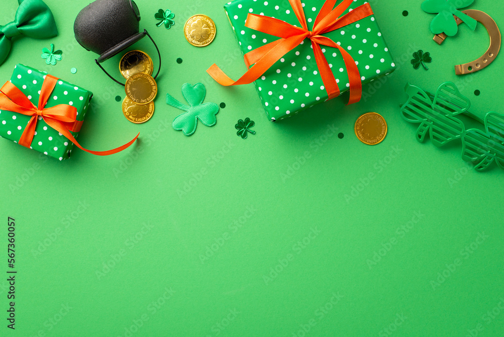 Saint Patrick's Day concept. Top view photo of green gift boxes pot with gold coins trefoil shaped party glasses horseshoe tie bow shamrocks and confetti on isolated green background with copyspace