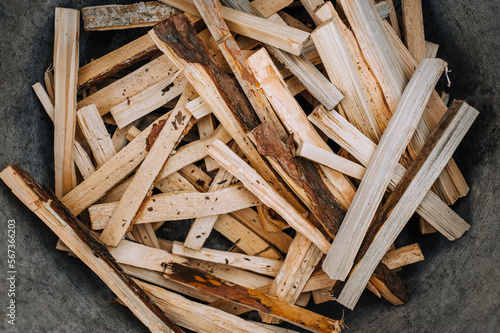 Chopped, sawn boards, firewood lie in a metal tank. Photo, texture, top view.