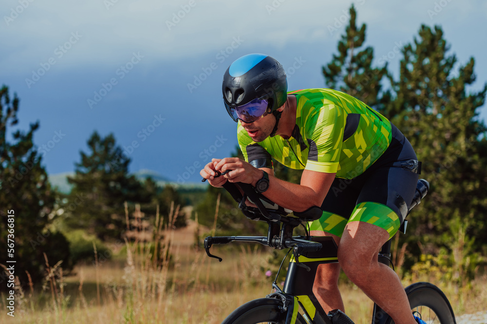 Full length portrait of an active triathlete in sportswear and with a protective helmet riding a bicycle. Selective focus Full length portrait of an active triathlete in sportswear and with a protective helmet riding a bicycle. Selective focus