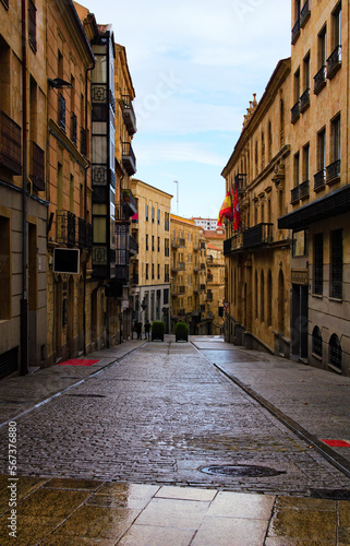 Scenic view of historical part of the city. Cobblestone street with old buildings in Salamanca, Spain. Ancient street with vintage houses. Rainy day in the city