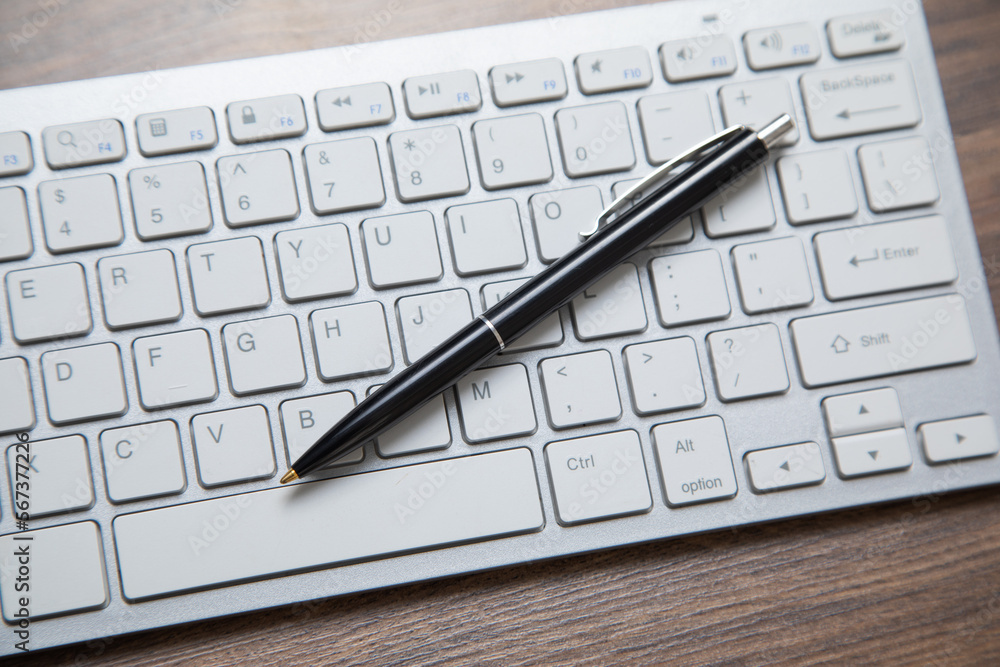 Black pen on the computer keyboard. Black pen on the computer keyboard.