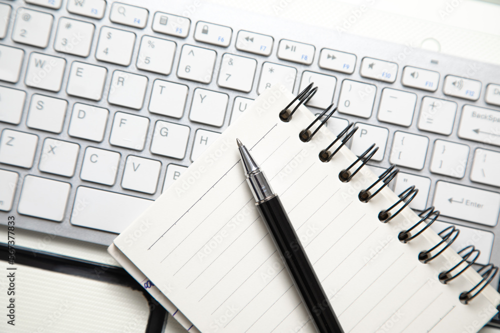 Pen and notepad on the computer keyboard. Pen and notepad on the computer keyboard.