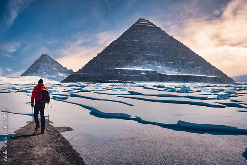 hiking man with backpack staying on stone path looking at the great pyramid of Giza covered with snow and ground with ice frozen landscape of egypt, generative AI