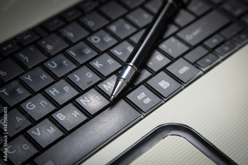 Black pen on the computer keyboard. Black pen on the computer keyboard.