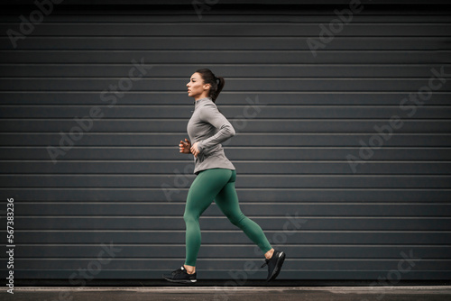 A female urban jogger is jogging in city.