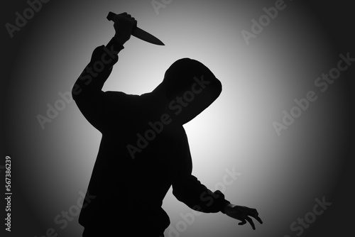Принти на полотні Mysterious man wearing black hoodie holding a knife to stab someone