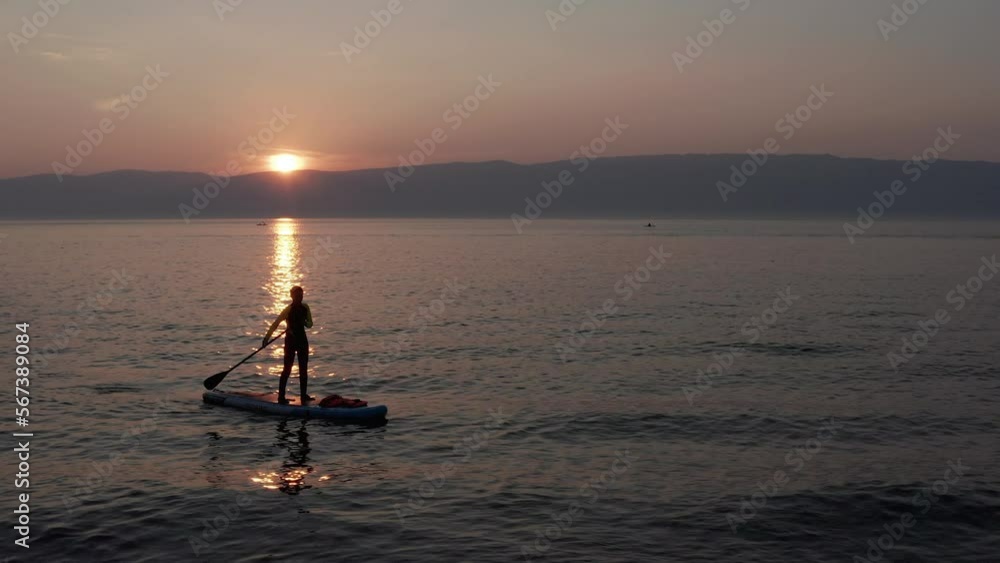 Stand up paddle board silhouette of alone woman on water, aerial SUP Stand up paddle board silhouette of alone woman on water, aerial SUP