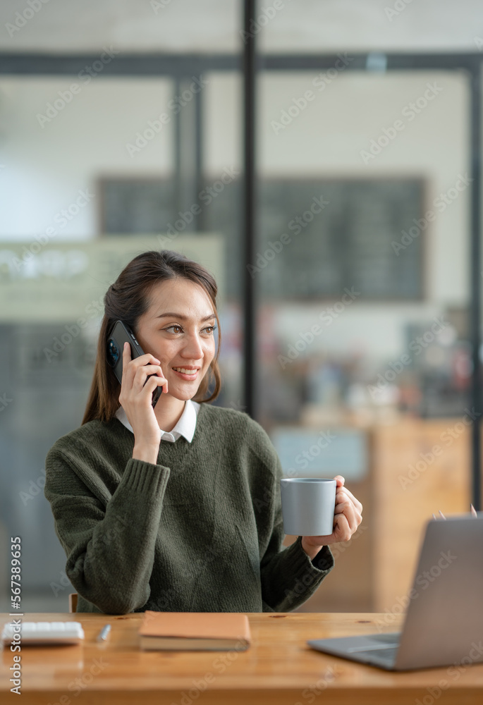 Attractive Asian businesswoman doing business related to village building project contacting using a mobile phone to chat and Negotiate management ideas in her office. Attractive Asian businesswoman doing business related to village building project contacting using a mobile phone to chat and Negotiate management ideas in her office.