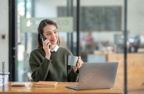 Beautiful and confident Asian businesswoman holding a cup of coffee to drink during break Relax with your own business happily in the office.
