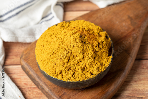 Fototapeta Naklejka Na Ścianę i Meble -  Curry Masala Powder. Turmeric powder or curry powder spice in a bowl on wooden background. İndian spices. Dry spice concept. close up