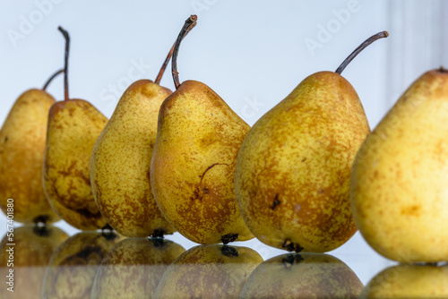 Close-up view of pears on glass table with reflections photo