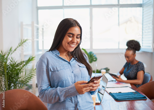 Young business woman using cellphone, colleague in boardroom office space