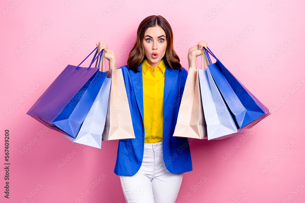 Photo of astonished impressed stunning lady hold many packs spend salary renew wardrobe clothes isolated on pink color background