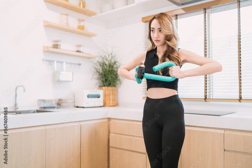 motivated pretty woman pushing exercise tool in kitchen. gorgeous exerciser exercising exercise tool for muscle indoors. beautiful woman training home fitness holding equipment for healthy arm muscle motivated pretty woman pushing exercise tool in kitchen. gorgeous exerciser exercising exercise tool for muscle indoors. beautiful woman training home fitness holding equipment for healthy arm muscle