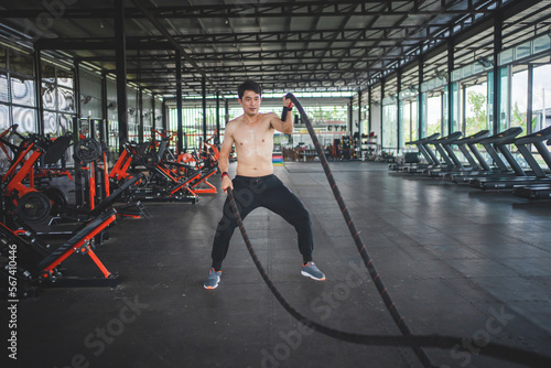 sportsman doing alternating rope waves in cross training workout.