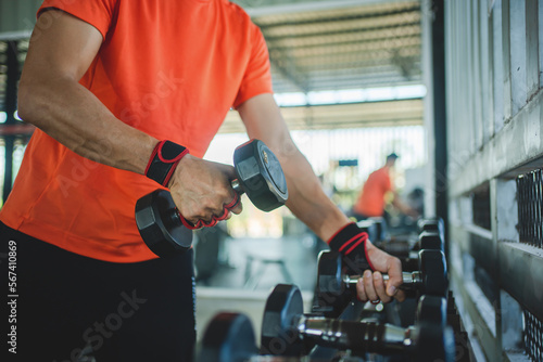 young man working out with dumbbells in the gym