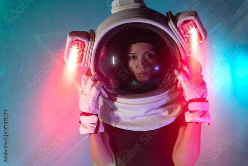 Woman in cosmonaut helmet with neon light photo