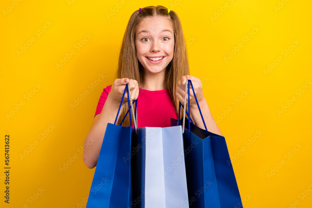 Photo portrait of young teenager girl shopaholic buy new clothes zara brand collection hold bags from boutique ad isolated on yellow color background