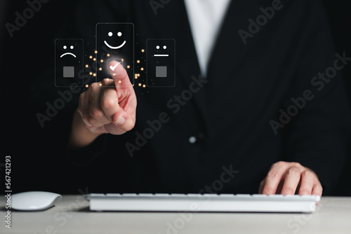 Customer service and satisfaction concept Business man touching virtual screen on happy smiley face icon to give service satisfaction very impressive score.