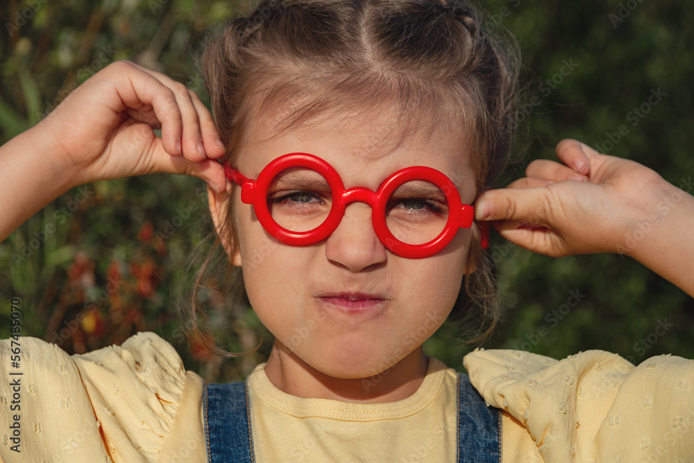 Portrait of capricious funny little girl in red fake glasses Portrait of capricious funny little girl in red fake glasses