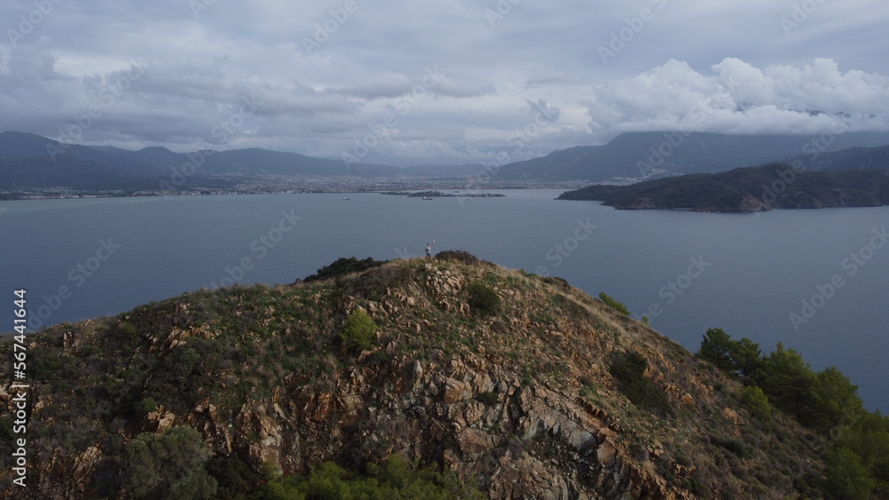 A man on top of an Kizil Ada island looks out into the Mediterranean sea from a drone.