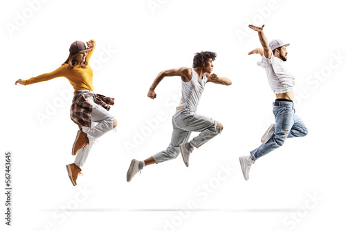 Fototapeta Naklejka Na Ścianę i Meble -  Full length profile shot of a caucasian male and female and an african american male dancers jumping