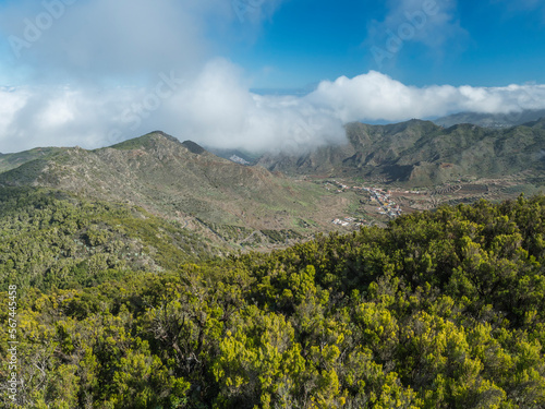 View from Baracan mountain. Green forest, hills and valley with terraced fields and village Las Portelas at Park rural de Teno, Tenerife, Canary Islands, Spain. sunny day, blue sky photo