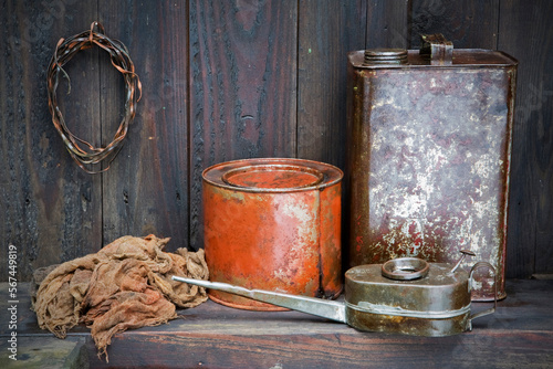 Digital photography depicting my grandfather's workstation with old paint canisters, rusted wire and oilcan on the weather-beaten wood background