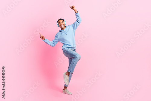 Full length photo of positive glad man wear stylish clothes look empty space sale modern technology shop isolated on pink color background