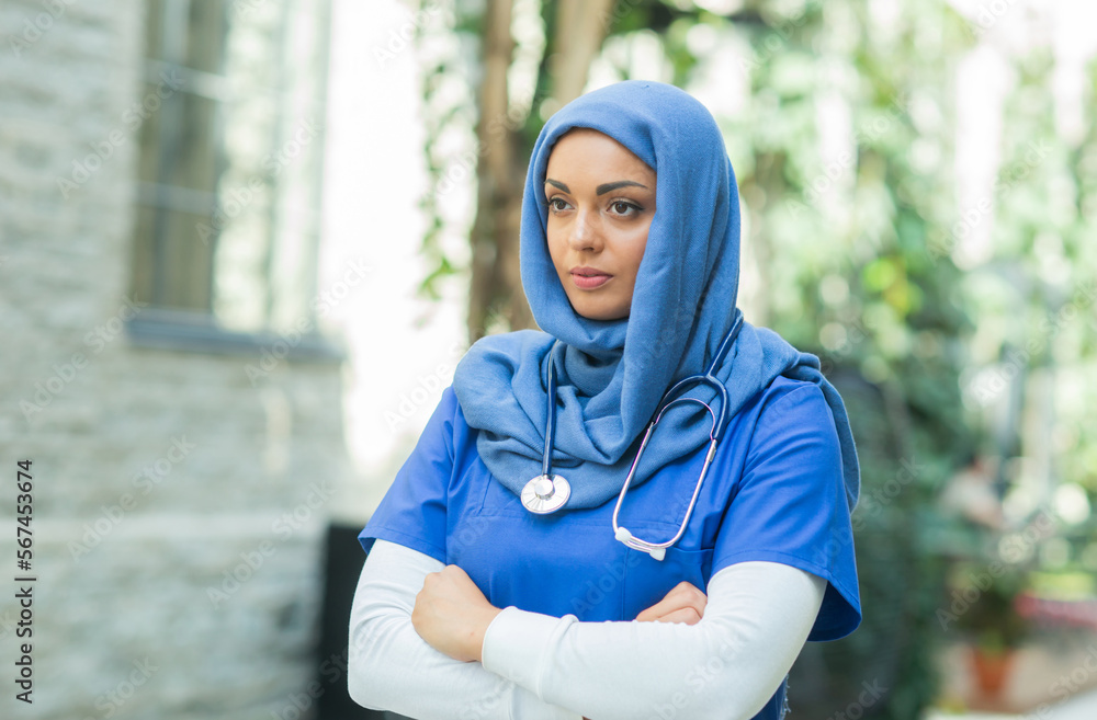 Close-up portrait of young and attractive muslim woman nurse in hijab. Middle Eastern female doctor outdoor on the street. City background. Medicine and health care concept. Close-up portrait of young and attractive muslim woman nurse in hijab. Middle Eastern female doctor outdoor on the street. City background. Medicine and health care concept.