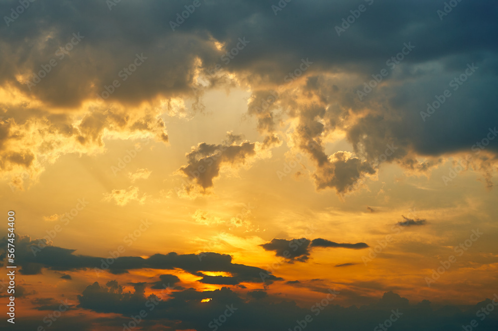 Summer sky at sunset, golden light from the sun colors the sky, thunderclouds and cumulus clouds give the sky a dramatic look, sky landscape
